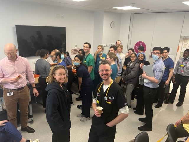 group of people in a room, more looking at camera