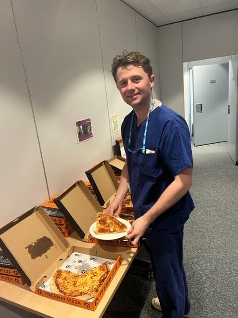 man stood with pizzas
